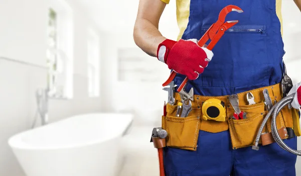 the torso of a plumbing technician showing a tool belt